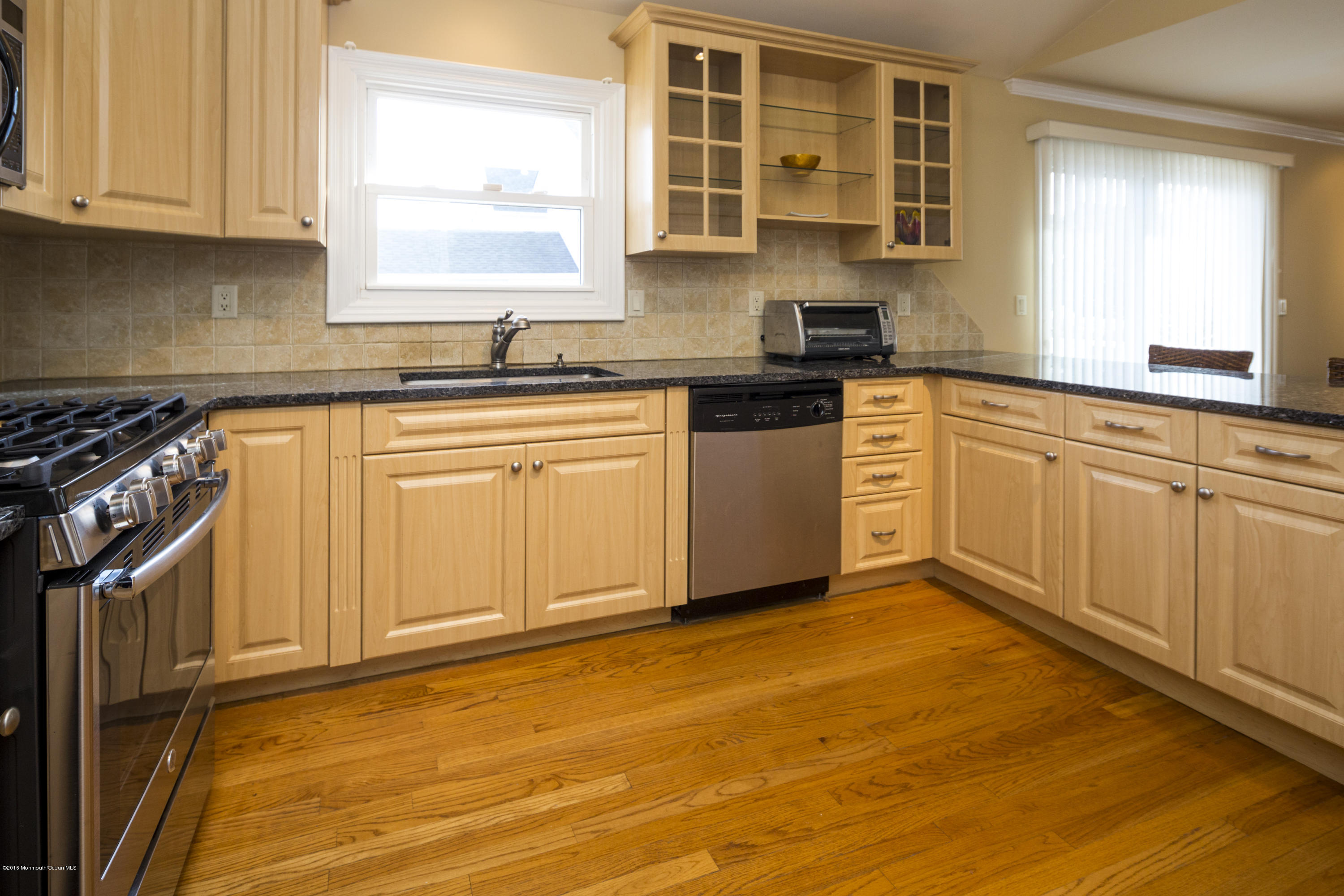 41 White Street Long Branch, NJ 07740 - Photo 12 of 29 a kitchen with granite countertop white cabinets sink and window