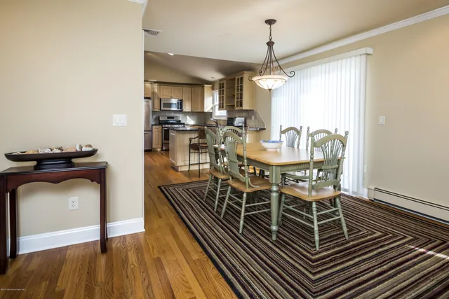 a dining room with furniture a chandelier and wooden floor