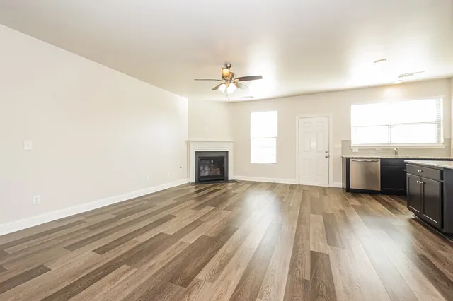 wooden floor in an empty room with a kitchen