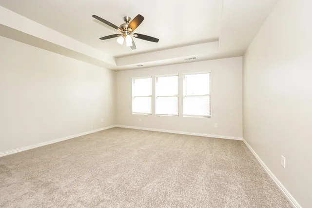 an empty room with a window and a fan