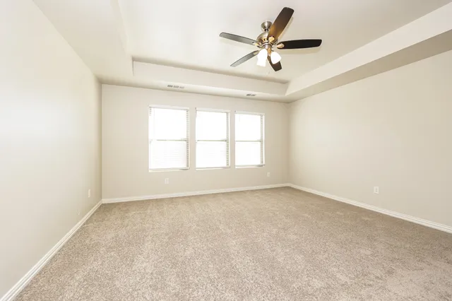 an empty room with a window and a fan