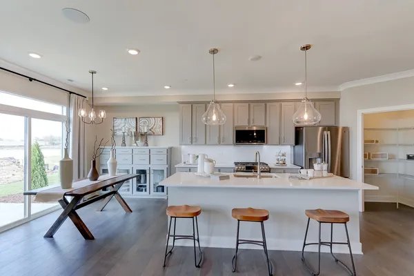 a kitchen with a dining table chairs wooden floor dining table and stainless steel appliances