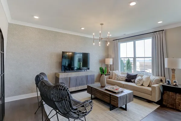 a living room with furniture a flat screen tv and a large window