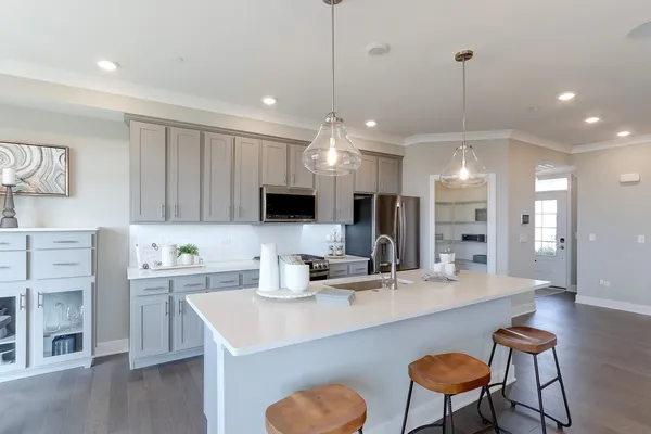 a kitchen with kitchen island a sink counter and chairs