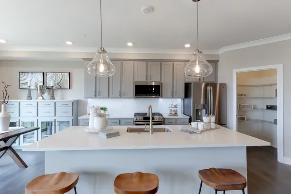 a kitchen with kitchen island a sink and a chandelier