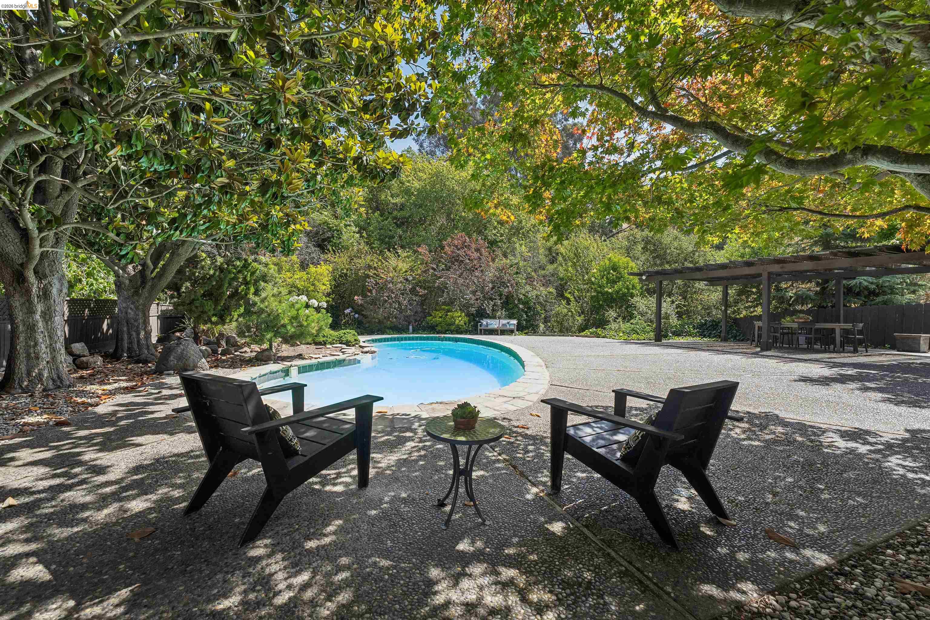 7 Jo Lin Court El Sobrante, CA 94803 - Photo 87 of 99 Curved swimming pool with stone coping, surrounded by an exposed aggregate patio