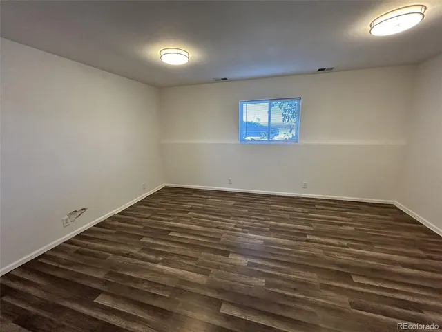 a view of a room with wooden floor and white walls