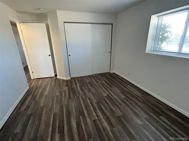 an empty room with wooden floor and a window