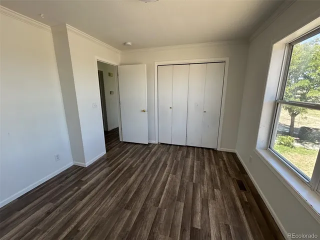 a view of a room with wooden floor and window
