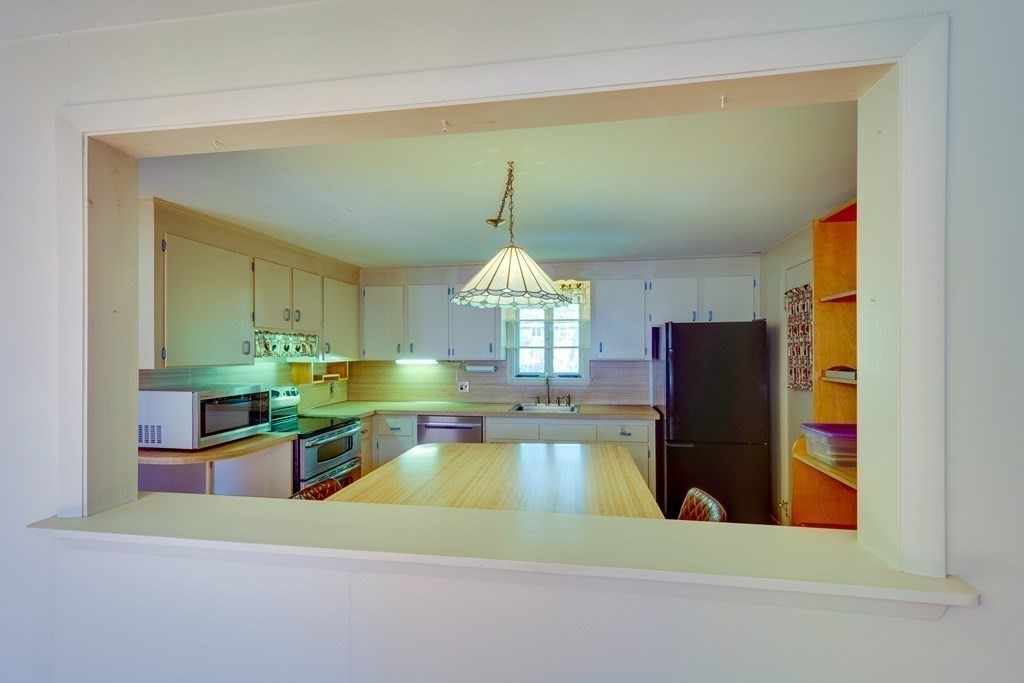 23 Fairmeadow Road Wilmington, MA 01887 - Photo 5 of 24 a kitchen with a refrigerator a stove and a microwave oven