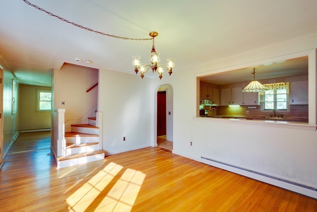 23 Fairmeadow Road Wilmington, MA 01887 - Photo 8 of 24 a view of a bedroom with wooden floor and a chandelier