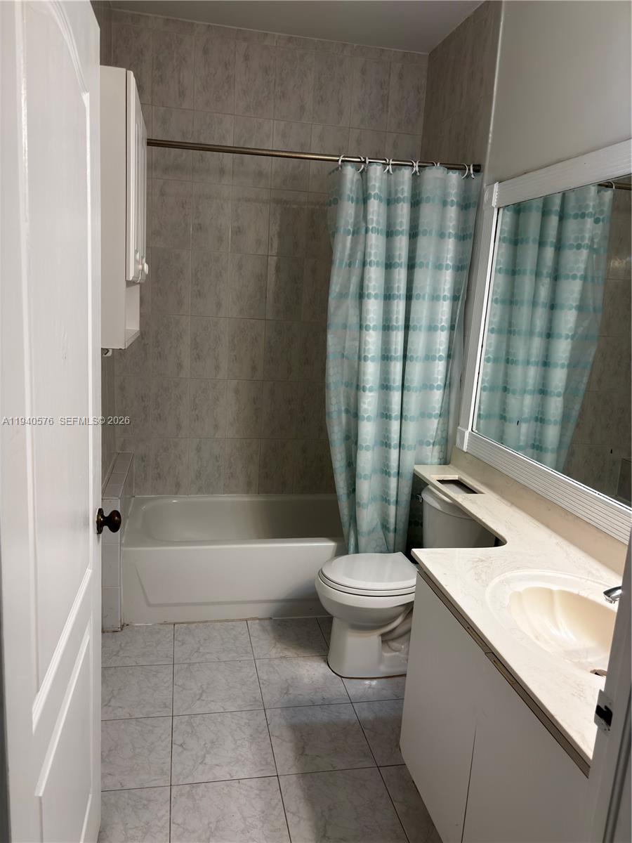 12645 Southwest 91st Street, Unit 2014 Miami, FL 33186 - Photo 11 of 15 a bathroom with a granite countertop bathtub sink vanity mirror and toilet