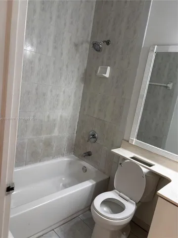 a white toilet and tub next to a shower