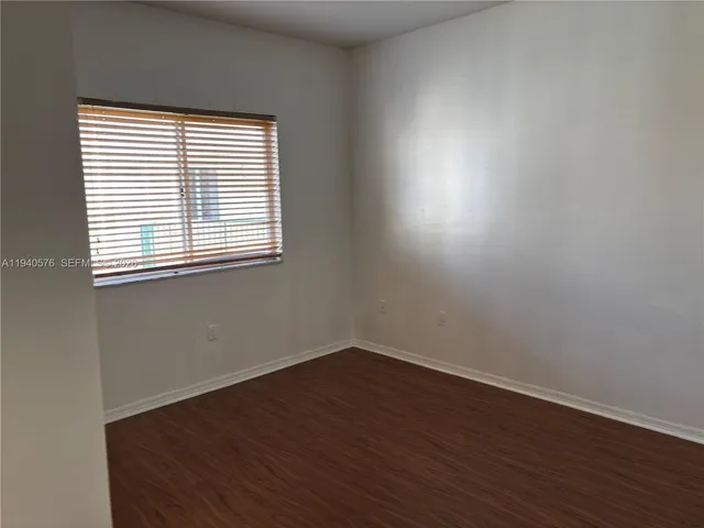 an empty room with wooden floor and a window