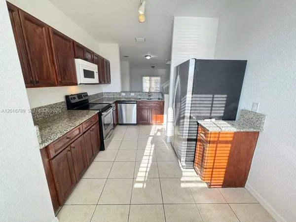 a kitchen with stainless steel appliances granite countertop a stove top oven a sink dishwasher and a microwave oven on the blue kitchen countertops