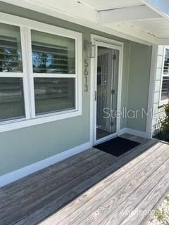 a view of a hallway with wooden floor and cabinet