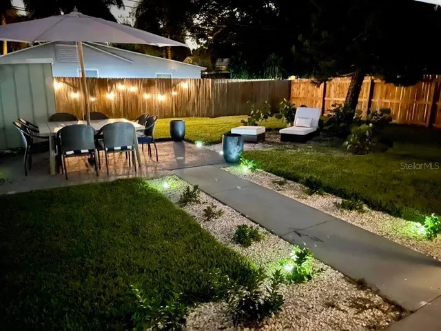 a view of a patio with table and chairs potted plants fire pit and outdoor seating