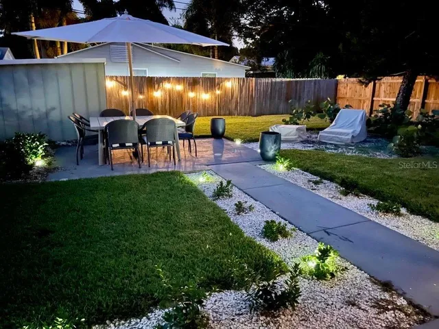 a view of backyard with seating space and wooden fence