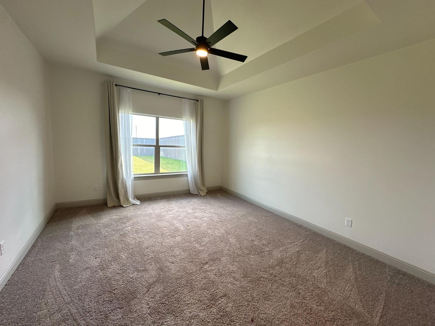 6959 103rd Street Lubbock, TX 79424 - Photo 12 of 49 an empty room with windows and fan