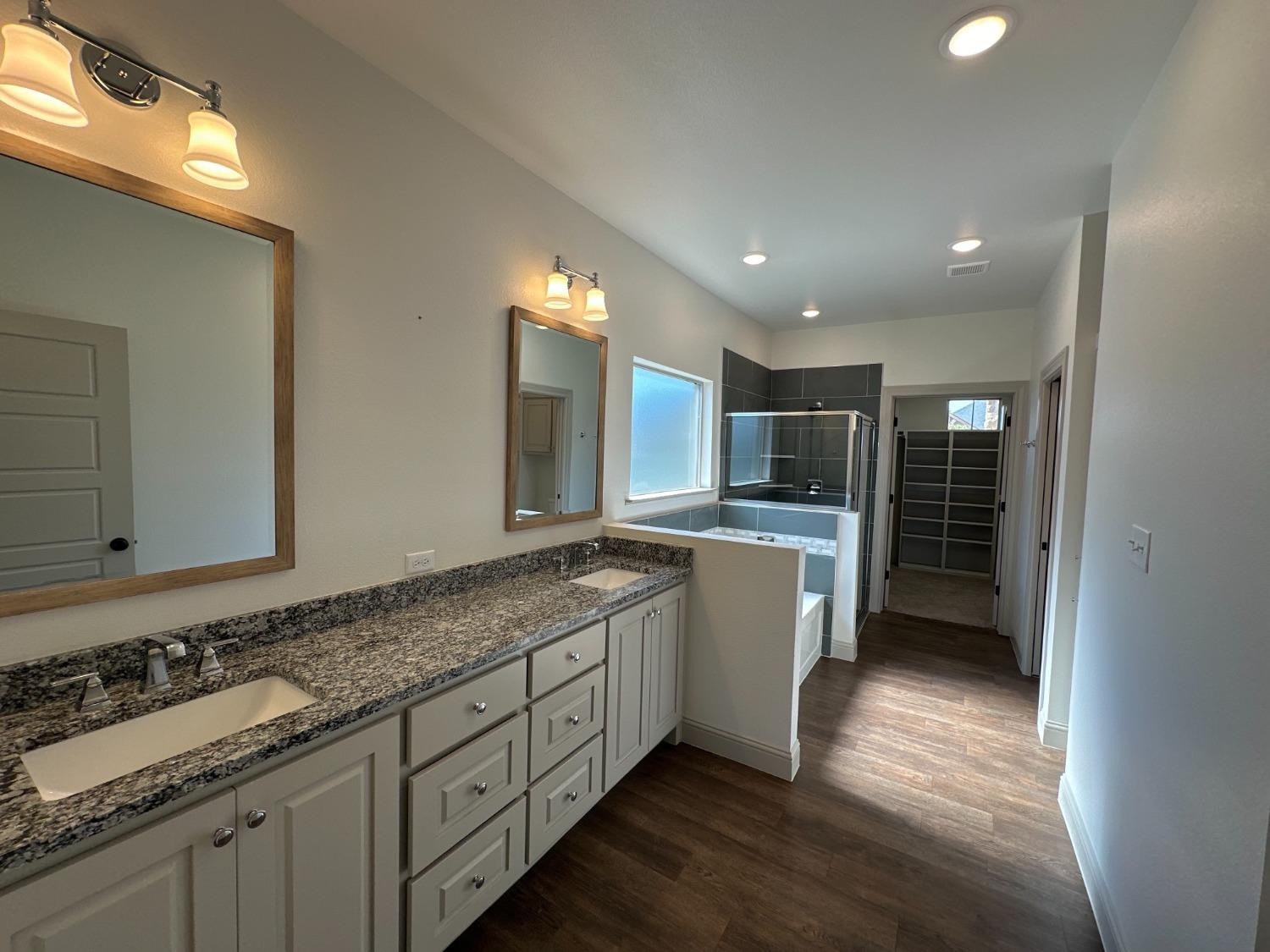 6959 103rd Street Lubbock, TX 79424 - Photo 14 of 49 a large bathroom with a sink and a large mirror