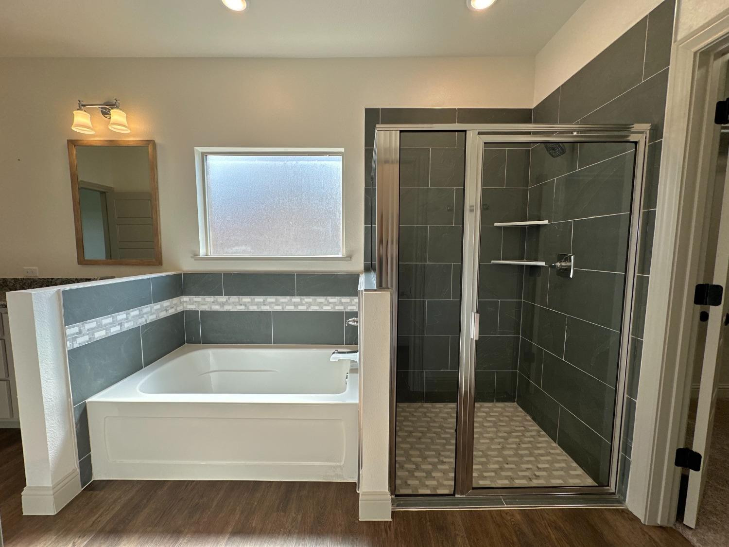 6959 103rd Street Lubbock, TX 79424 - Photo 17 of 49 a bathroom with a tub and shower