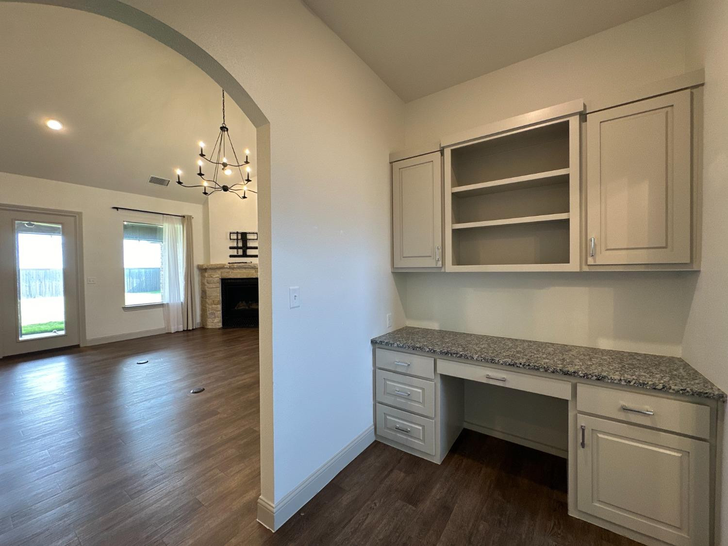 6959 103rd Street Lubbock, TX 79424 - Photo 25 of 49 a hallway with cabinets and wooden floor