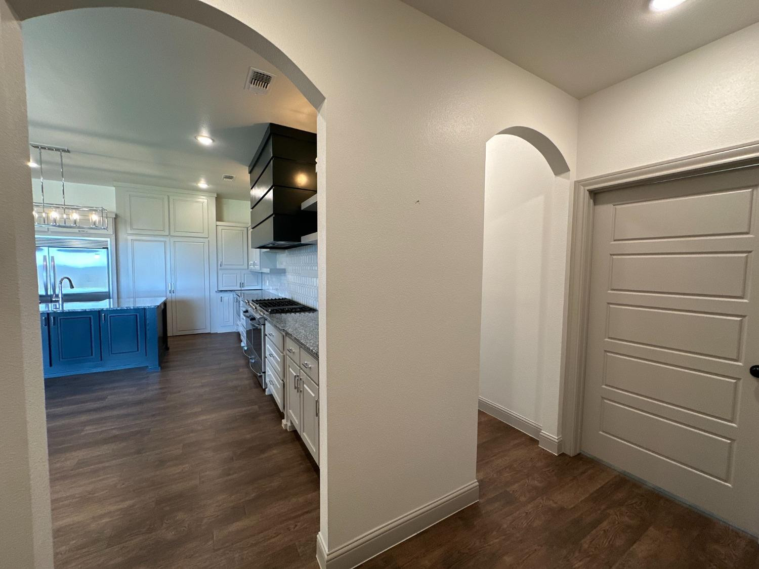 6959 103rd Street Lubbock, TX 79424 - Photo 29 of 49 wooden floor in an empty room and a kitchen
