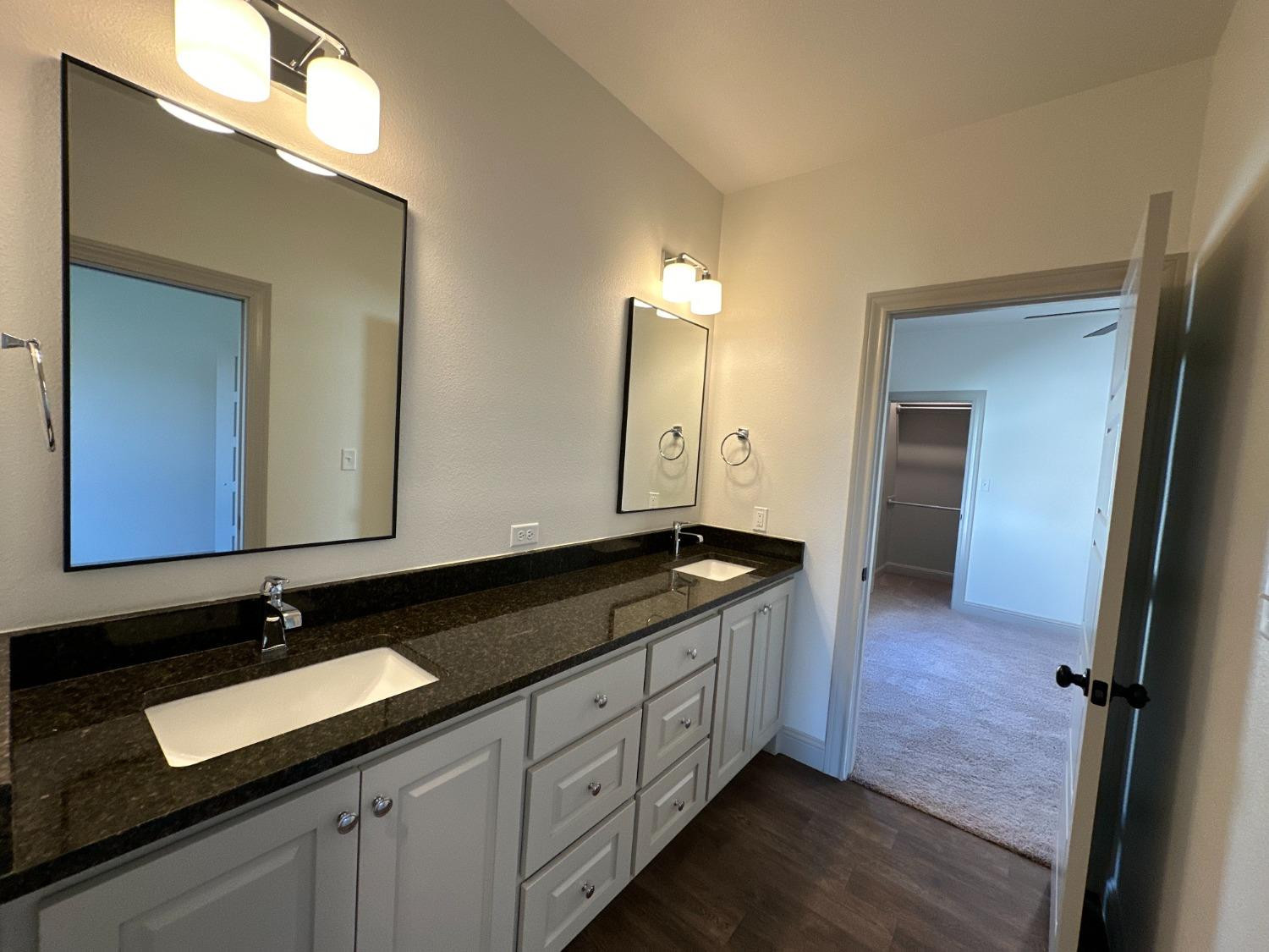 6959 103rd Street Lubbock, TX 79424 - Photo 39 of 49 a spacious bathroom with a granite countertop sink and a mirror