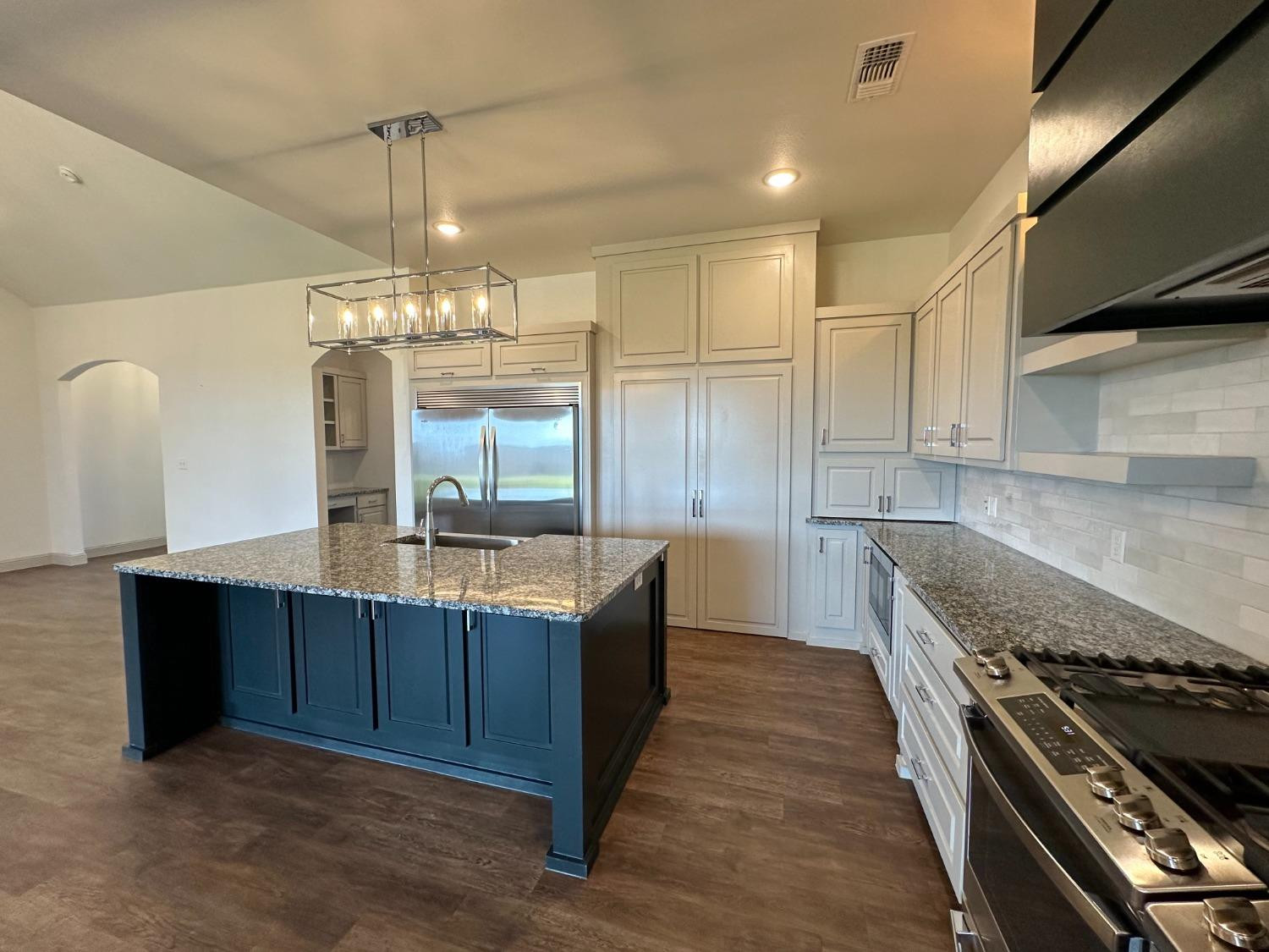 6959 103rd Street Lubbock, TX 79424 - Photo 8 of 49 a large kitchen with granite countertop a stove and a sink
