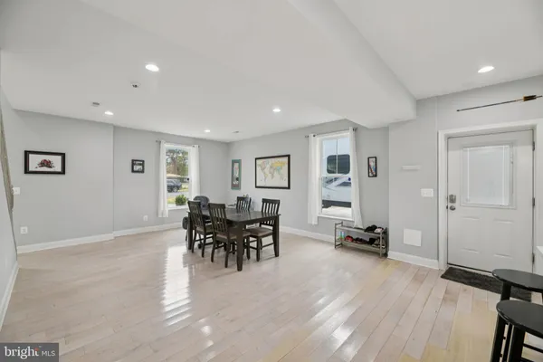 a spacious bedroom with a bed a dresser and a window
