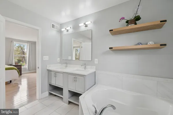 a spacious bedroom with a bed and wooden floor