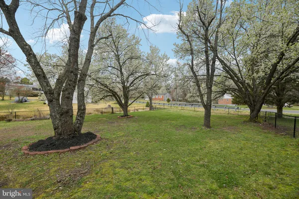 a front view of a house with a garden and trees