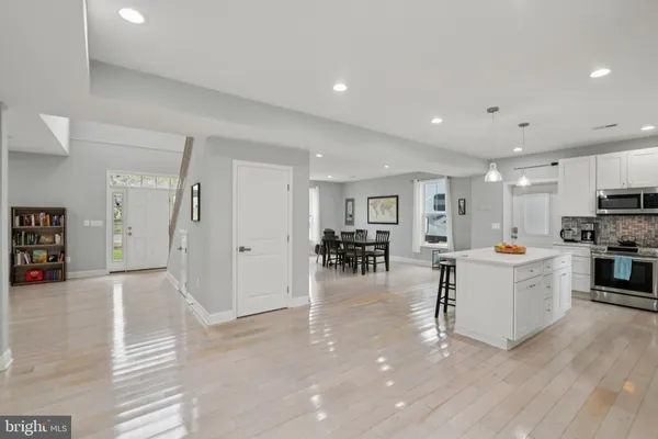 a kitchen with a dining table chairs sink and cabinets