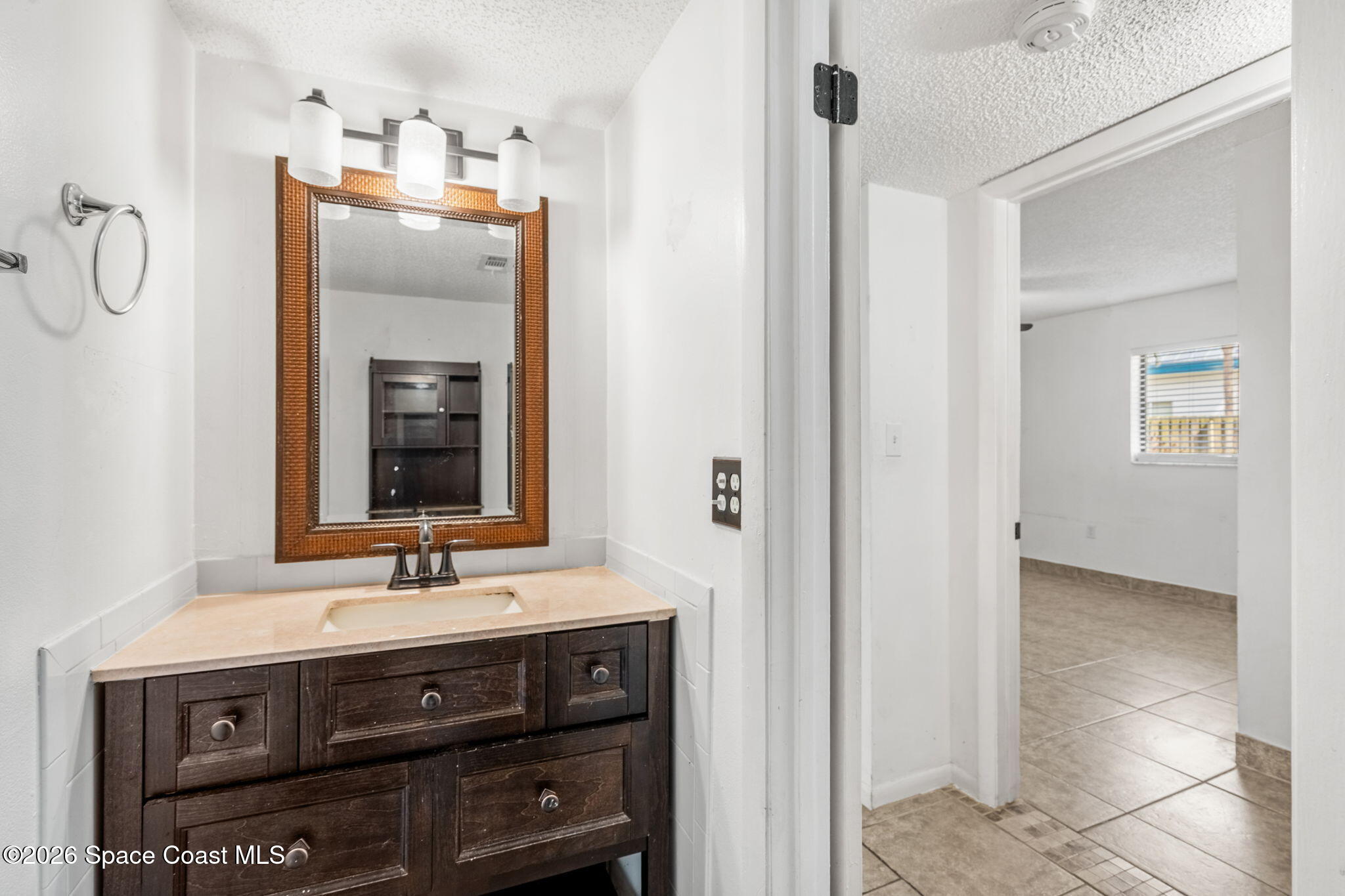 500 Catalina Road, Unit 402 Cocoa Beach, FL 32931 - Photo 16 of 34 a bathroom with a sink vanity and a mirror