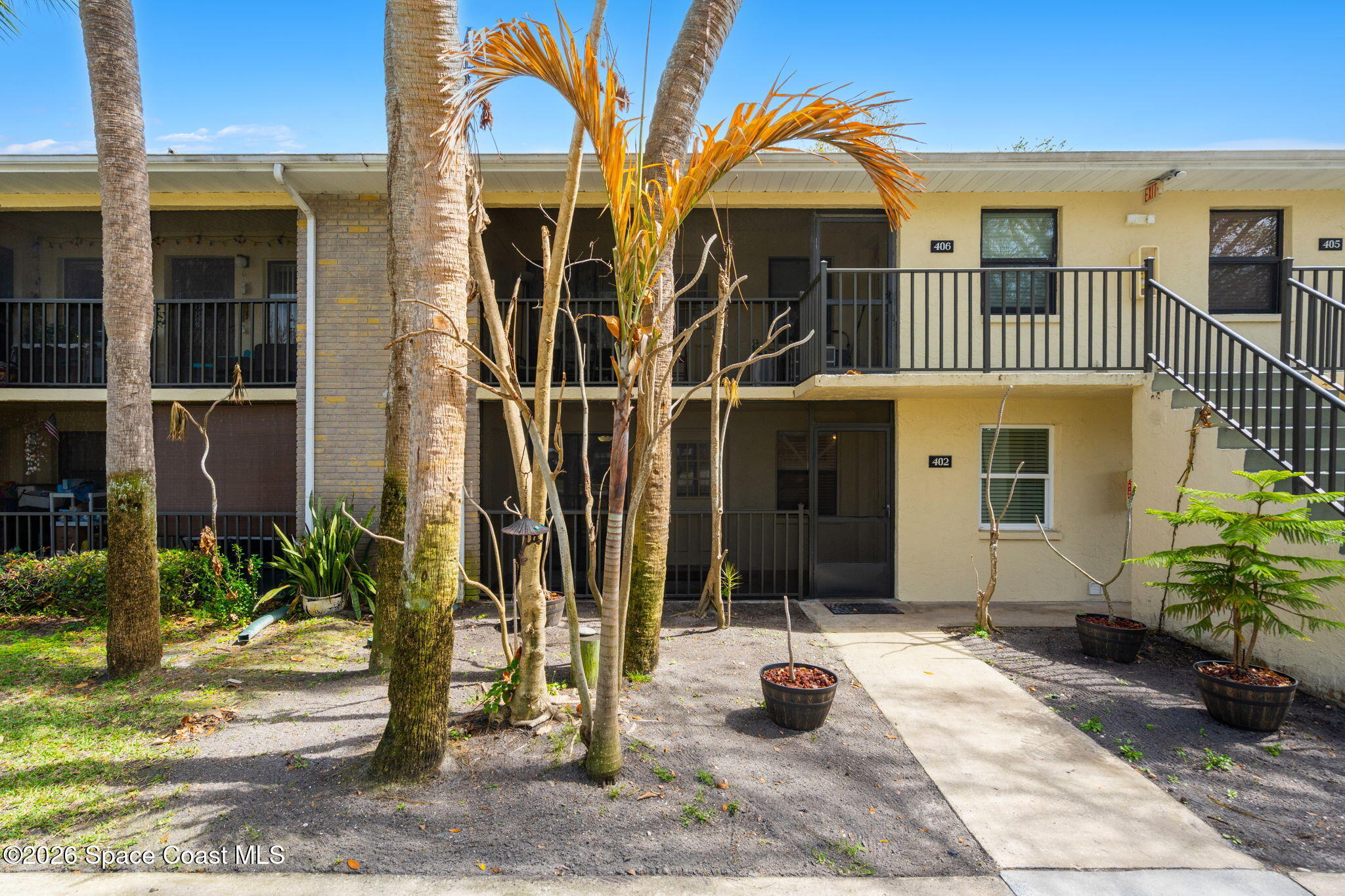 500 Catalina Road, Unit 402 Cocoa Beach, FL 32931 - Photo 22 of 34 a view of a brick house with many windows and plants
