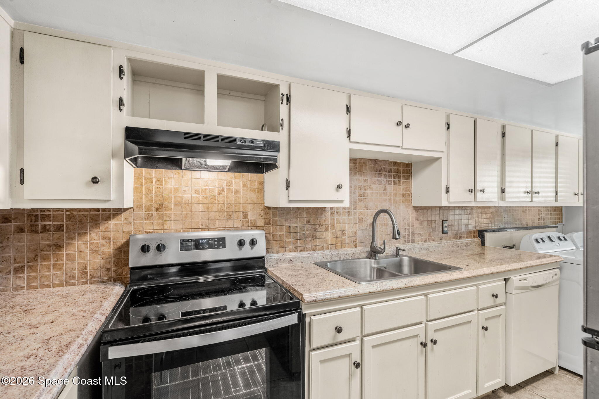 500 Catalina Road, Unit 402 Cocoa Beach, FL 32931 - Photo 5 of 34 a kitchen with cabinets and appliances