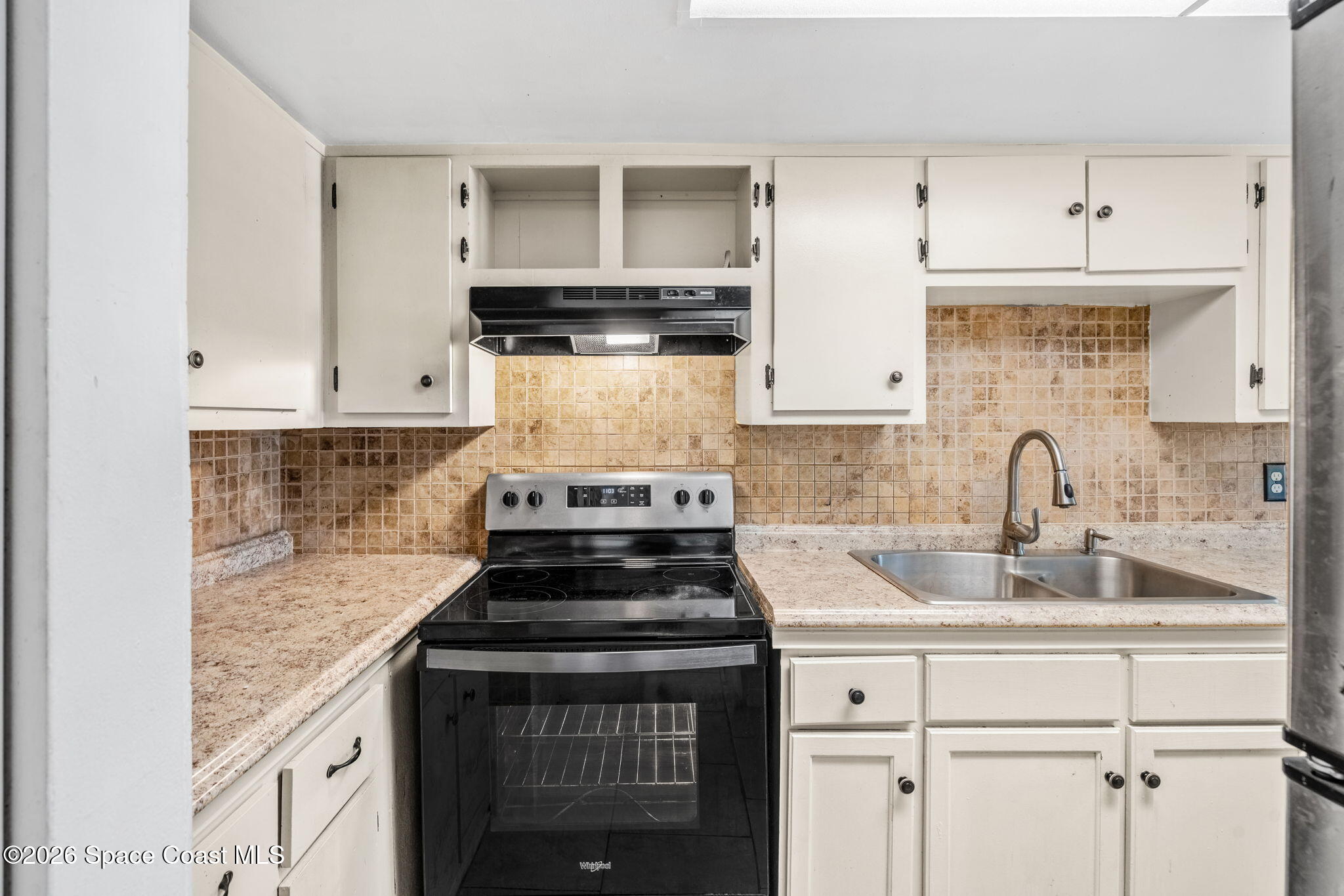 500 Catalina Road, Unit 402 Cocoa Beach, FL 32931 - Photo 6 of 34 a kitchen with granite countertop a stove sink and cabinets