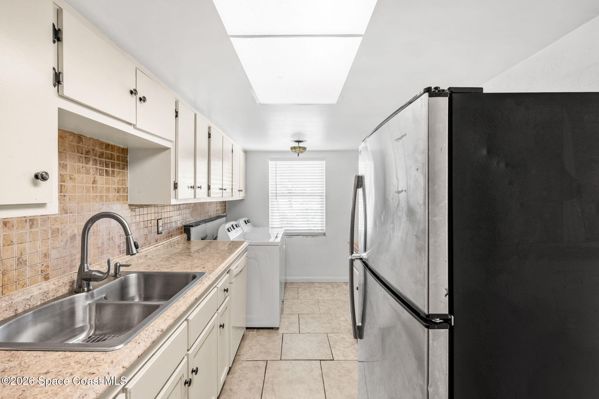 500 Catalina Road, Unit 402 Cocoa Beach, FL 32931 - Photo 8 of 34 a kitchen with a refrigerator sink and cabinets