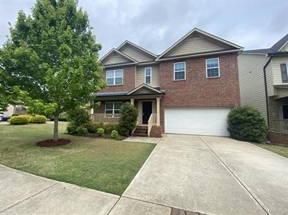 a front view of a house with a yard and trees