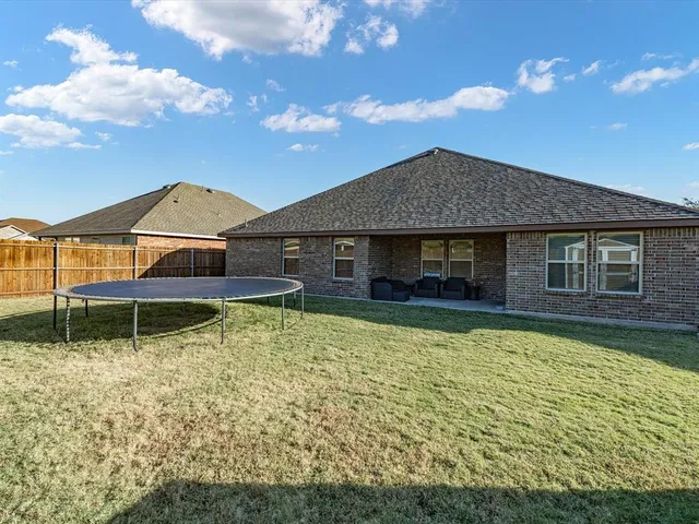 a backyard of a house with table and chairs
