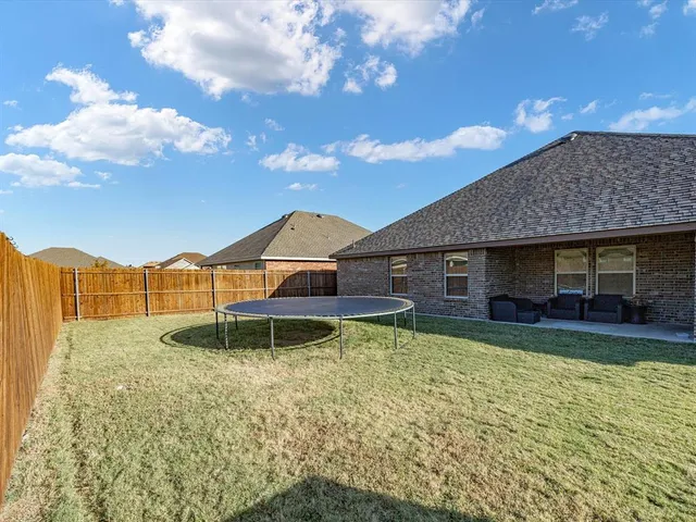 a backyard of a house with table and chairs