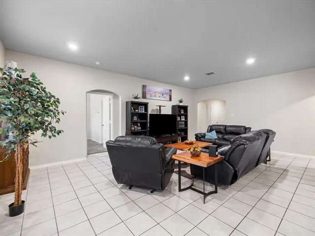 a living room with furniture a kitchen view and a fireplace