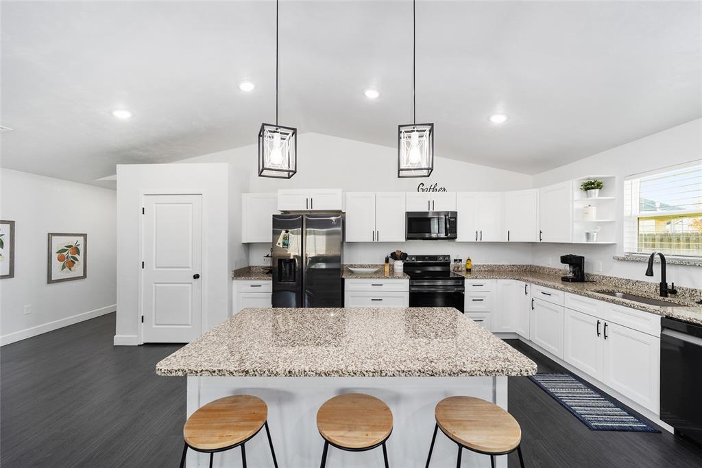 16668 Northwest 191st Way High Springs, FL 32643 - Photo 6 of 38 a kitchen with granite countertop a sink stainless steel appliances and white cabinets