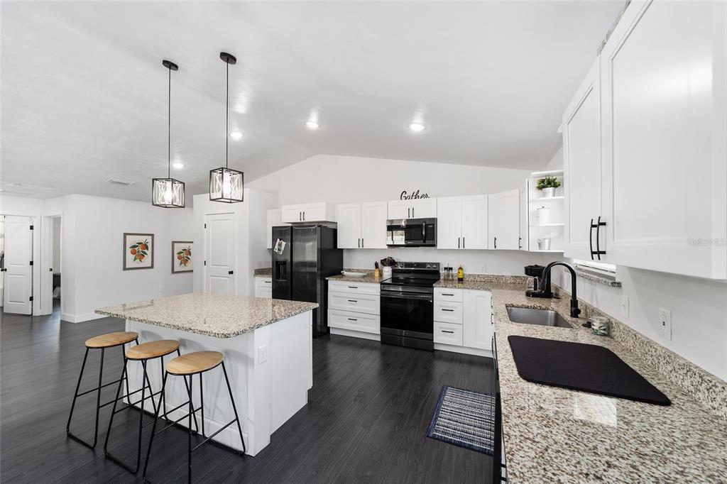 16668 Northwest 191st Way High Springs, FL 32643 - Photo 10 of 38 a kitchen with stainless steel appliances kitchen island granite countertop a sink and cabinets