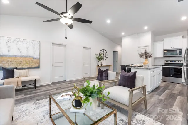 a living room with furniture and kitchen view