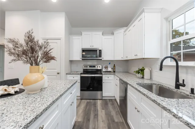 a kitchen with granite countertop a sink and a stove top oven