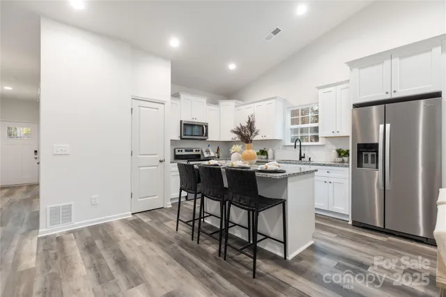 a kitchen with refrigerator cabinets and wooden floor