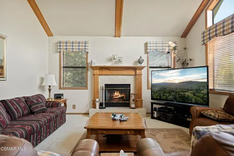 a living room with furniture a fireplace and a large window
