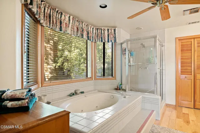 a bathroom with a tub a sink and a large window