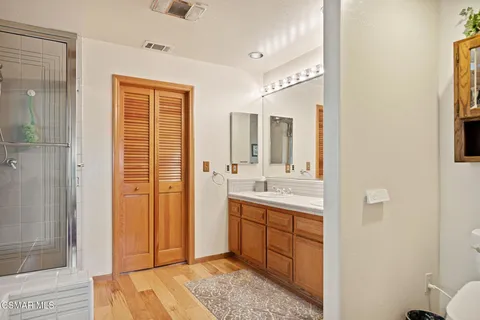 a spacious bathroom with a shower sink and mirror
